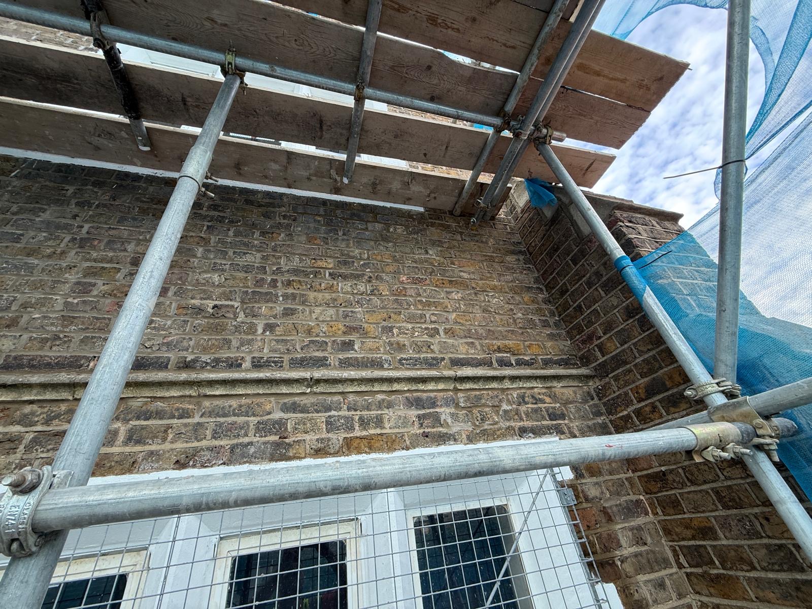 External brick elevation undergoing repointing works from scaffold access
