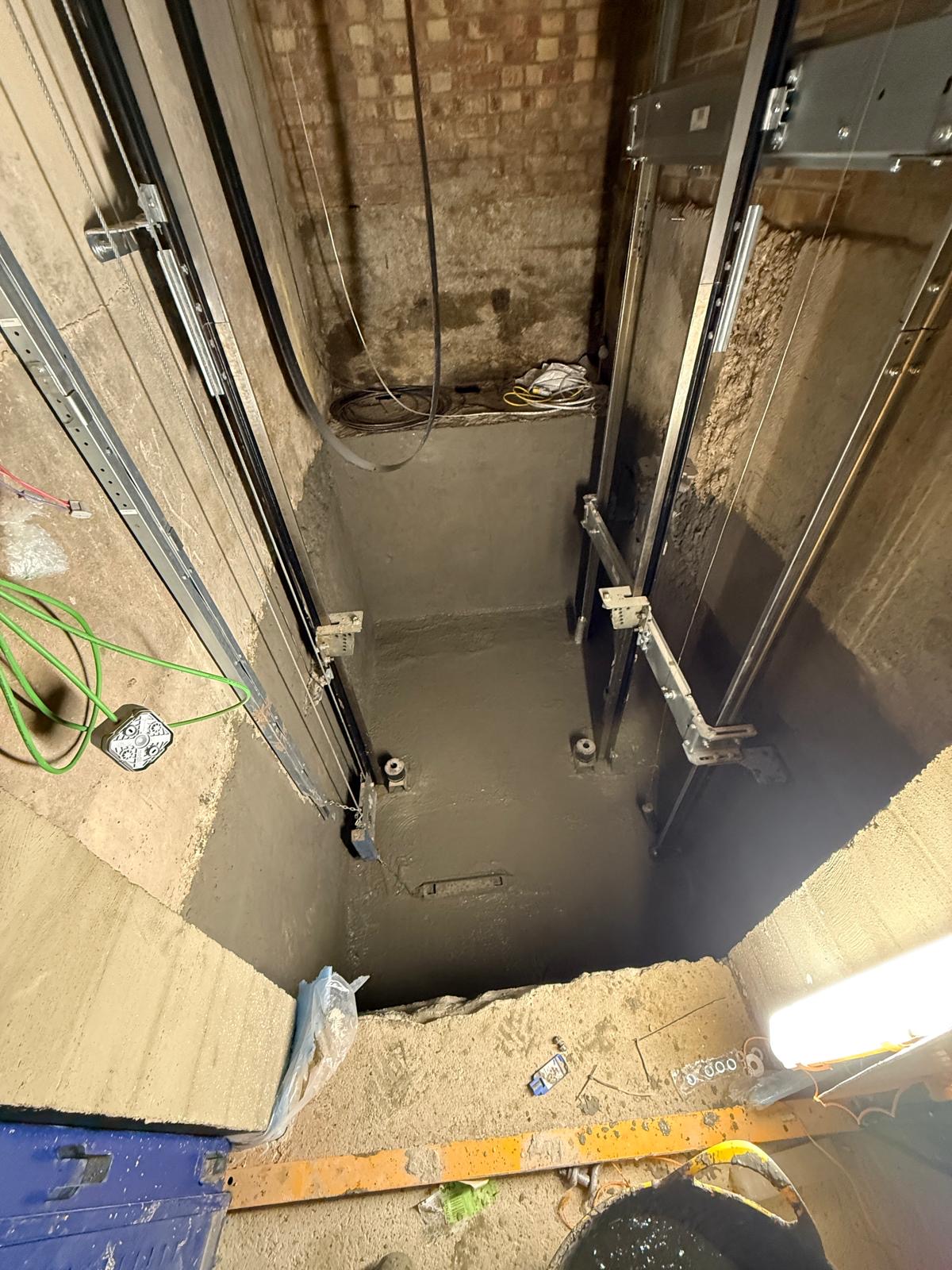 Lift pit with waterproofing treatment applied to the walls and floor