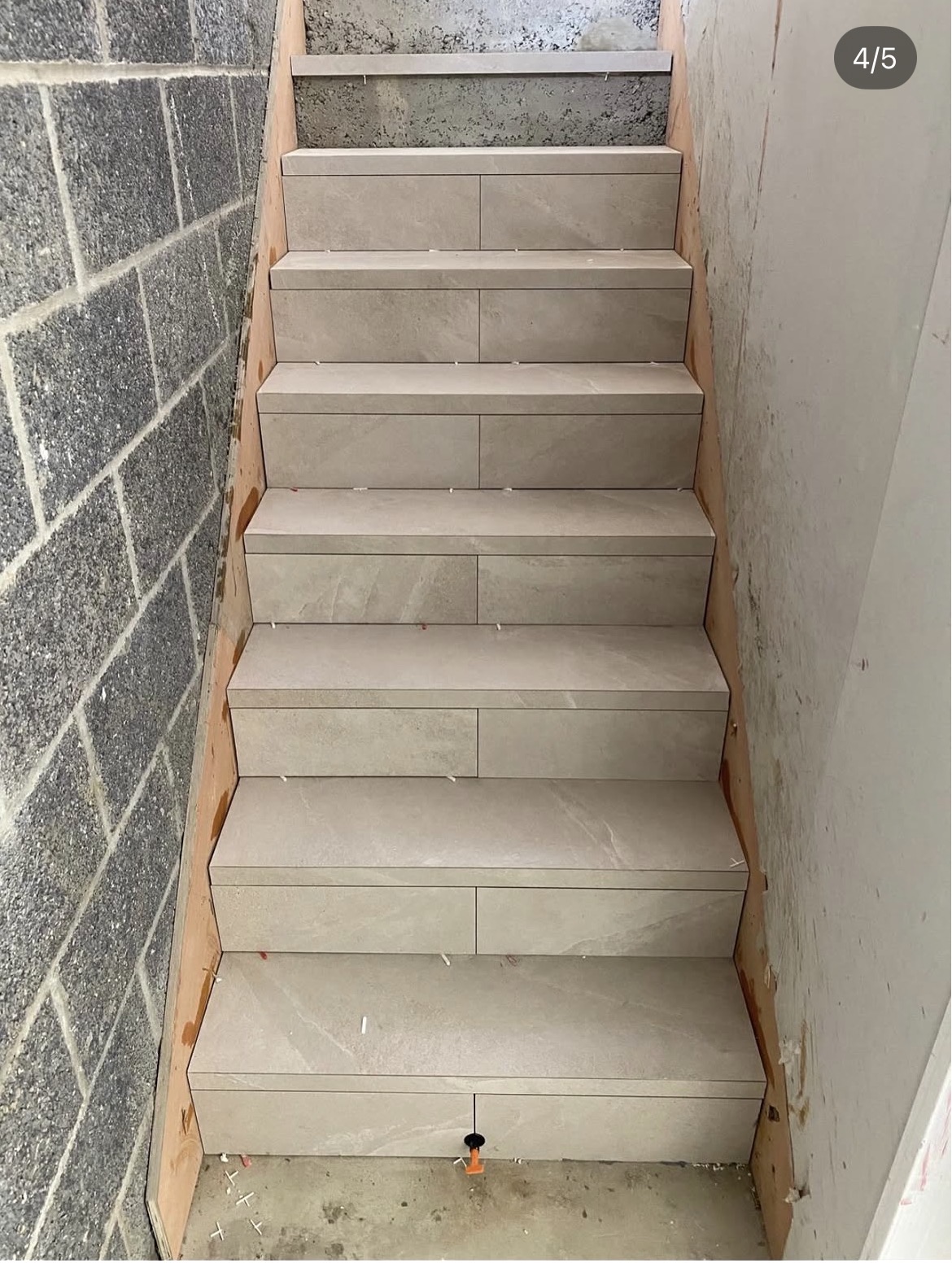 Grey tiles installed to staircase treads and risers during construction